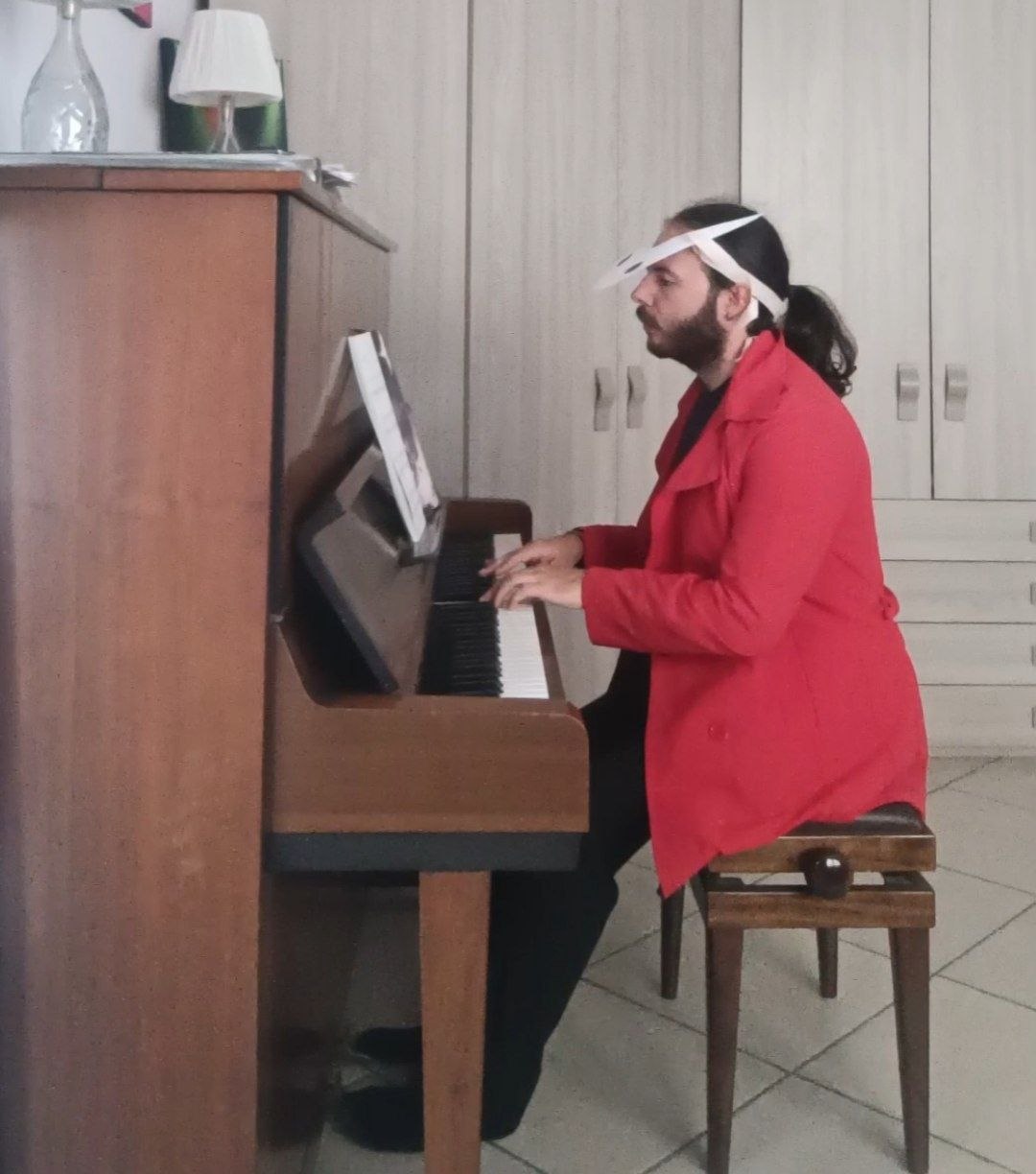 Me playing the piano dressed as Hornet from Hollow Knight: Silksong